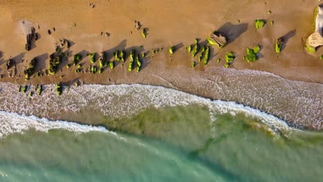 Suave-Cámara-Lenta-Playa-Dorada-Puesta-De-Sol-Paisaje-Aéreo-De-Erosión-Costera-Viento-Roca-Pulida-Cubierta-Por-Algas-Verdes-Cremosas-La-Espuma-De-La-Burbuja-De-La-Ola-En-La-Costa-Maravillosa-Aventura-Junto-Al-Mar-En-Un-Viaje-A-Irán