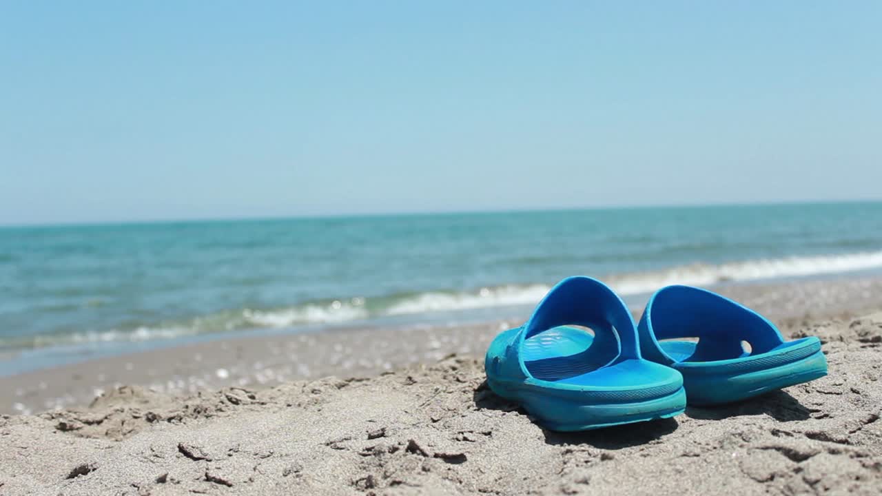 スリッパの背景でビーチを歩いている 3