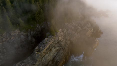 Wunderschöne-Drohnenaufnahme-Fängt-Goldenen-Nebel-über-Küstenklippen-Ein