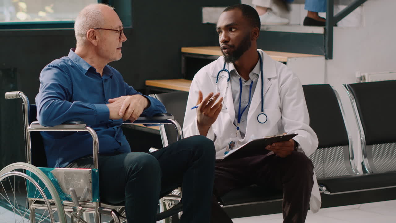 African american doctor doing consultation with old man in wheelchair