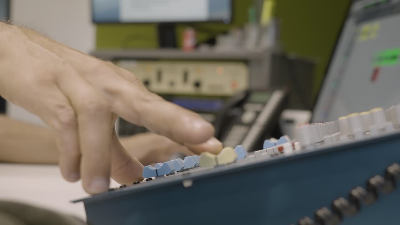 ingeniero de audio anónimo ajustando las perillas del mezclador de sonido en el estudio de grabación, cámara lenta