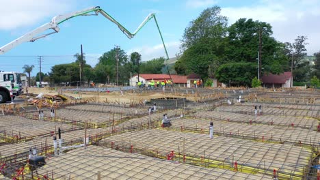 Remarkable Aerial Over Construction Site With Giant Crane And Workers Pouring Concrete Foundation In Ventura California