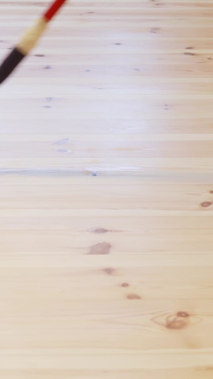 Detailed vertical shot of hardwood floor varnishing during a DIY renovation project