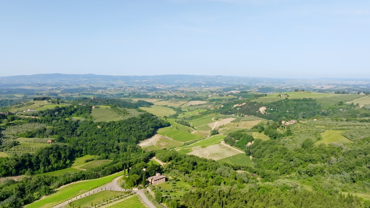 Aerial view rising in front of a house and green vineyards of Tuscany, Italy