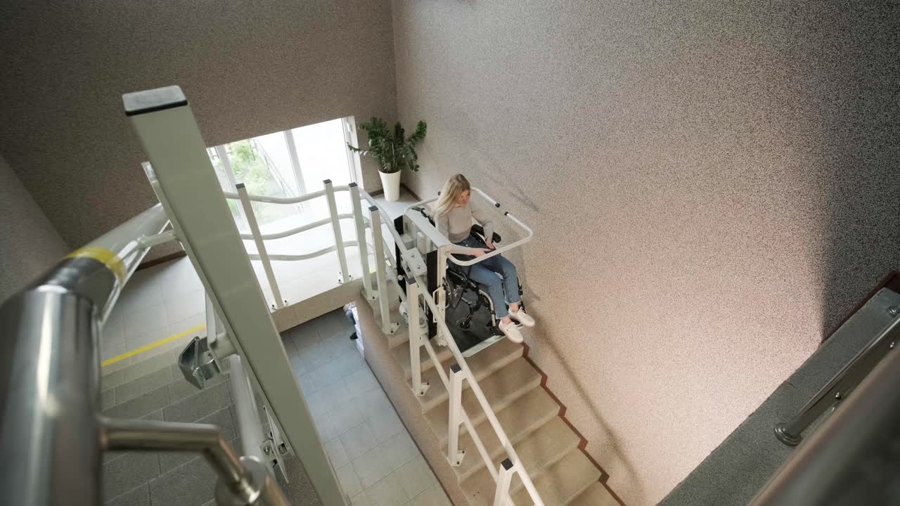una niña en silla de ruedas sube las escaleras sin esfuerzo usando un ascensor de escaleras.
