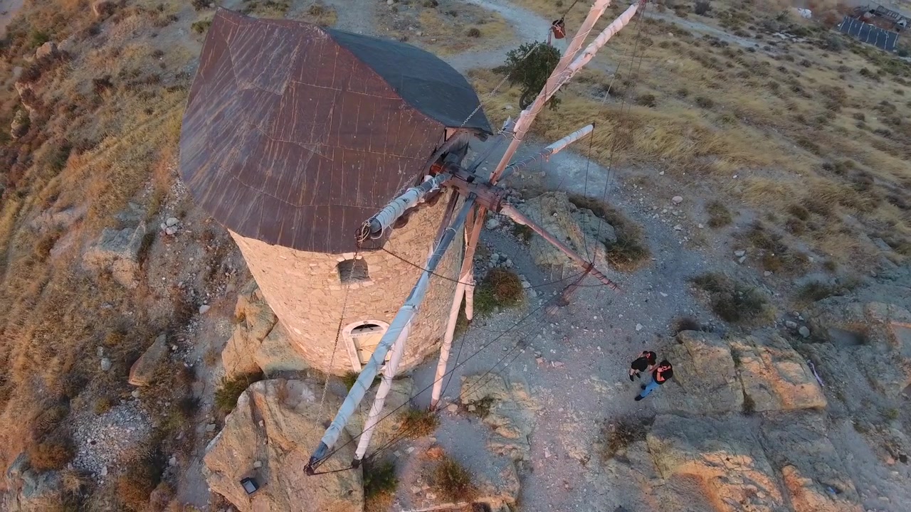 Aerial View of Two People Standing Near an Ancient Stone Windmill