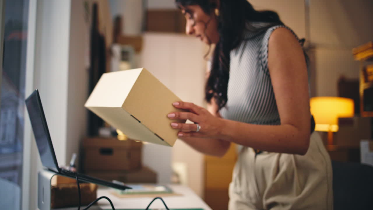 Woman Scanning Package Barcode and Typing on Laptop