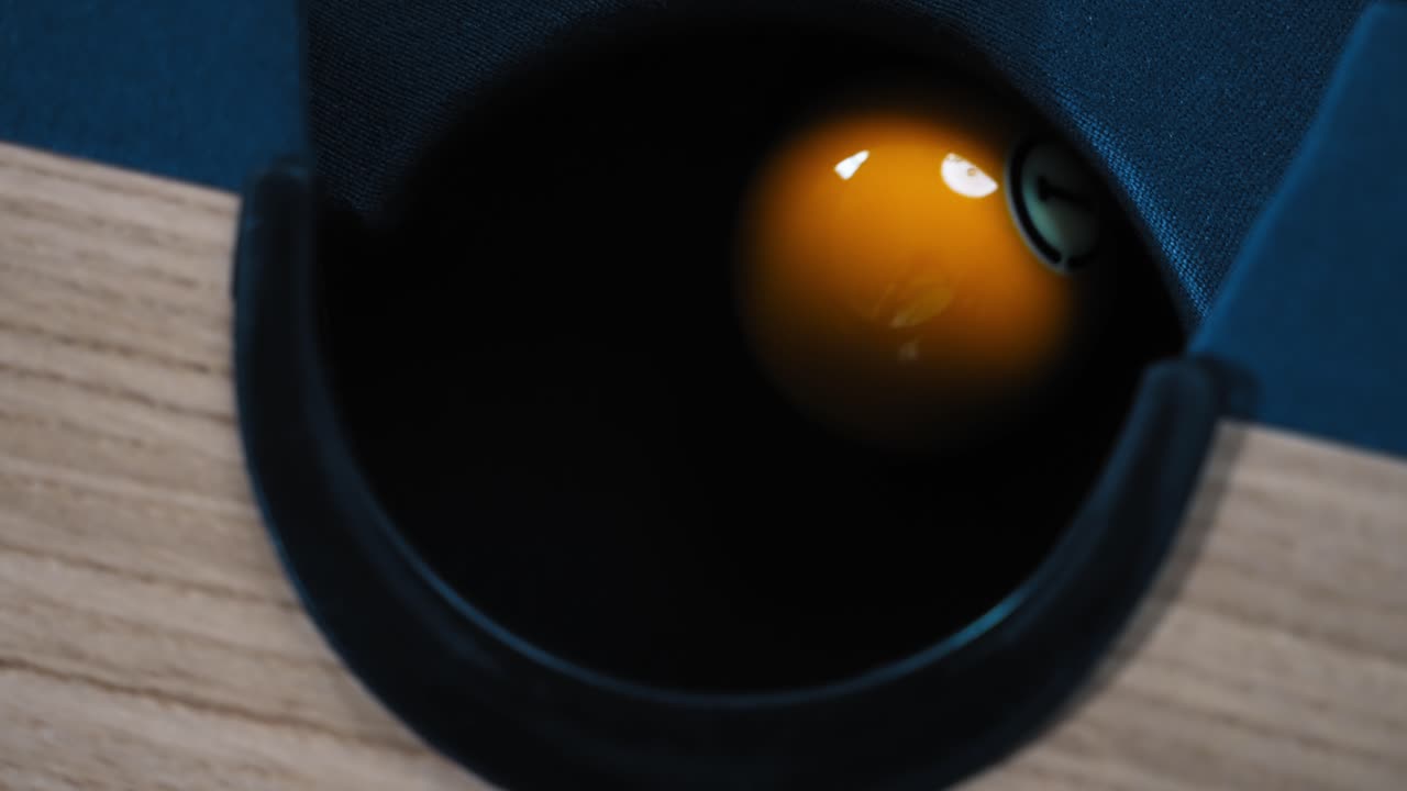 toma en cámara lenta de la bola número uno 1 que entra en el hoyo de un billar y rebota hacia adentro y hacia afuera