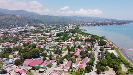 aerial drone of capital city dili in timor leste, south east asia, high up and lowering towards buildings, traffic and ocean