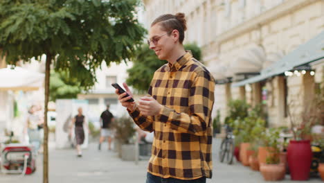man using smartphone typing texting social media messages looking for a way on map navigator app