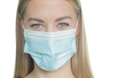 a woman adjusts her ppe mask and smiles