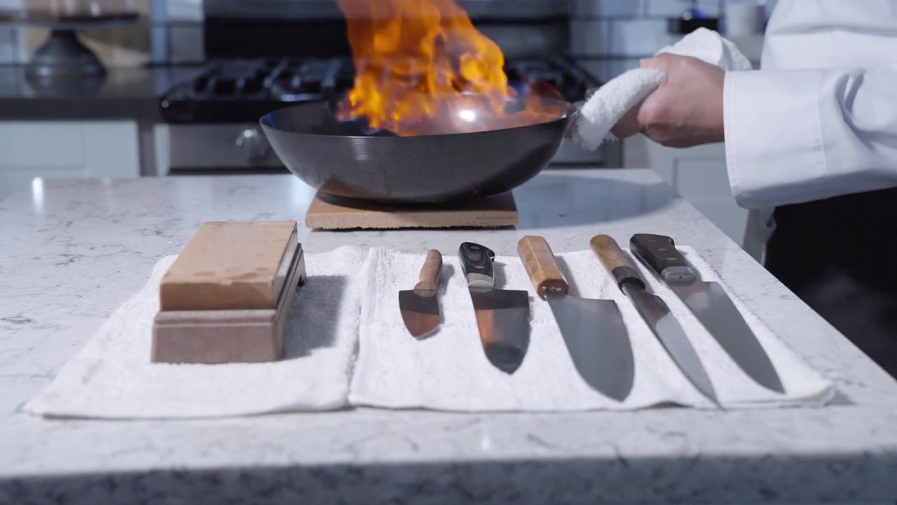 Static shot showcasing various cooking knives and a sharpener in a chef’s kitchen, emphasizing kitchen tools and culinary preparation. Perfect for culinary arts, cooking equipment, and kitchen setups.