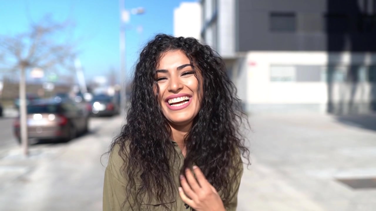 Giovane donna araba che muove i suoi capelli neri ricci