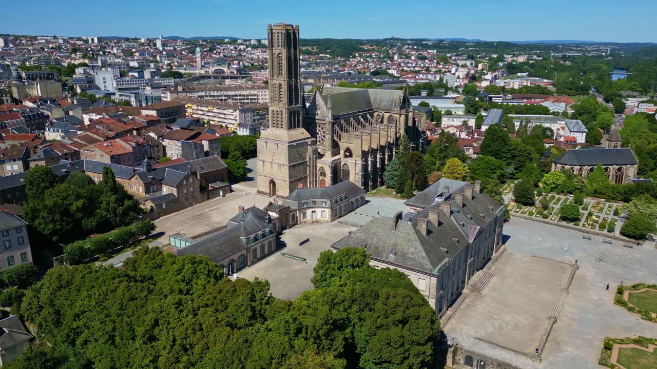 Aerial panning shot of Saint-Etienne Cathedral in Limoges, with surrounding buildings, vegetation, and cityscape - France