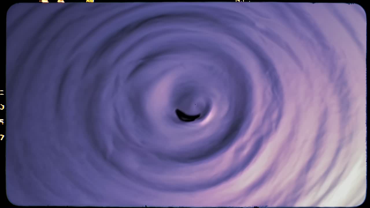 Abstract video of concentric ripples in purple hues, captured from a top-down angle