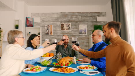 young man clinking a glass of wine with his family