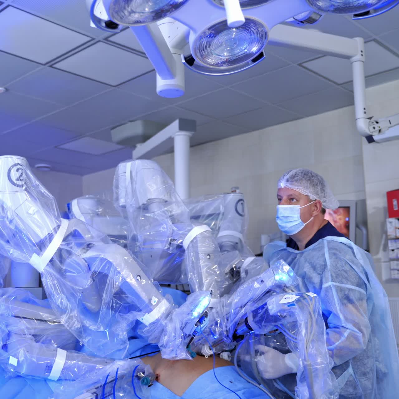 Medical robot. Doctor works with robotic equipment. Medical operation involving robot. Minimally invasive robotic surgery with the da Vinci surgical system.