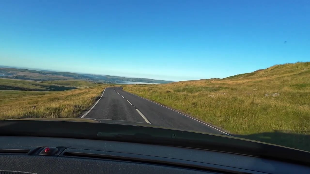 POV fra bilens instrumentbræt, der kører ad en landevej i det walisiske landskab Brecon Beacons i Wales, Storbritannien. Rejse- og eventyroptagelser.