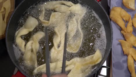 deep-frying angel wings dough in a pan with cooking oil