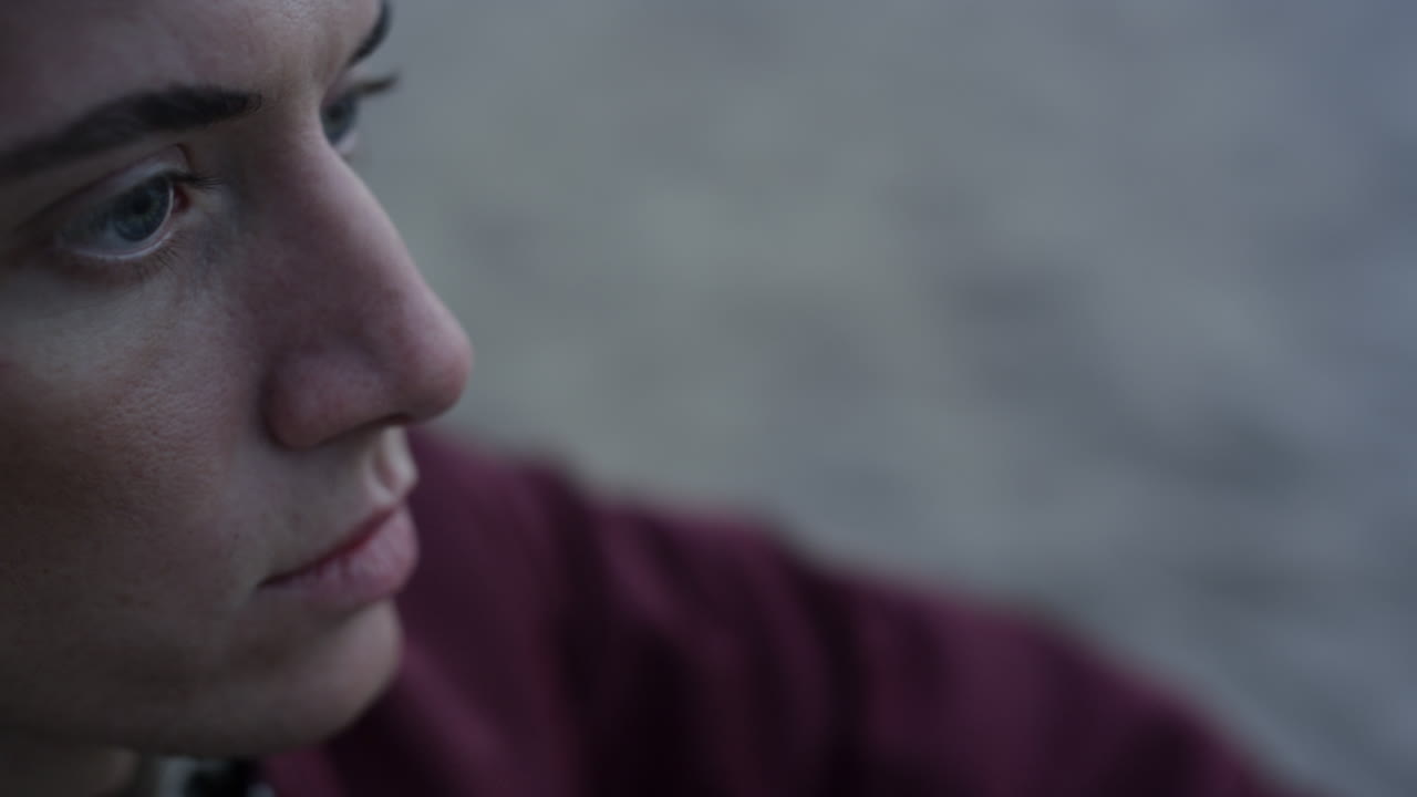 Closeup serious man sitting on beach. Handsome guy face with sad emotion