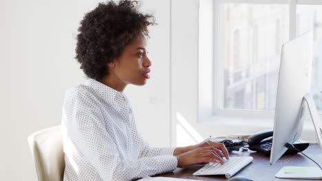 young black woman working at computer in an office, close up
