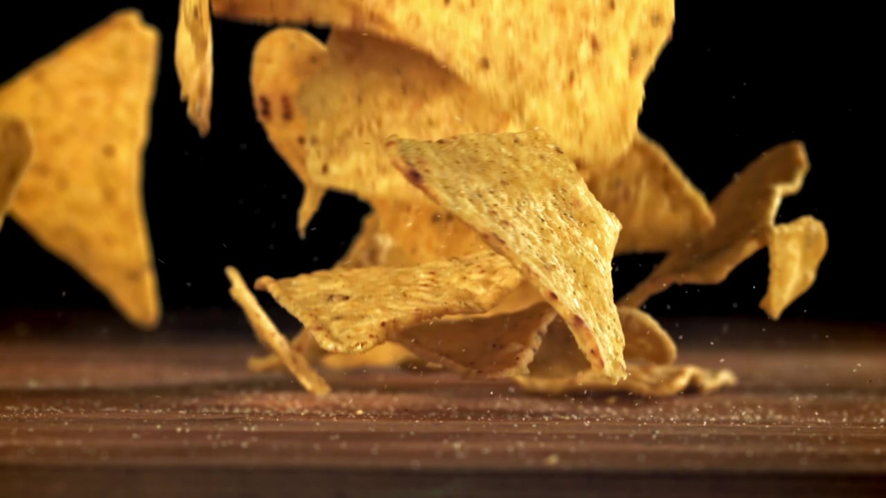 Tortillachips som faller ner på en träyta i slow motion