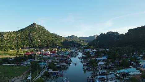 imágenes aéreas a la izquierda que revelan un pueblo de pescadores, un barco moviéndose en el medio