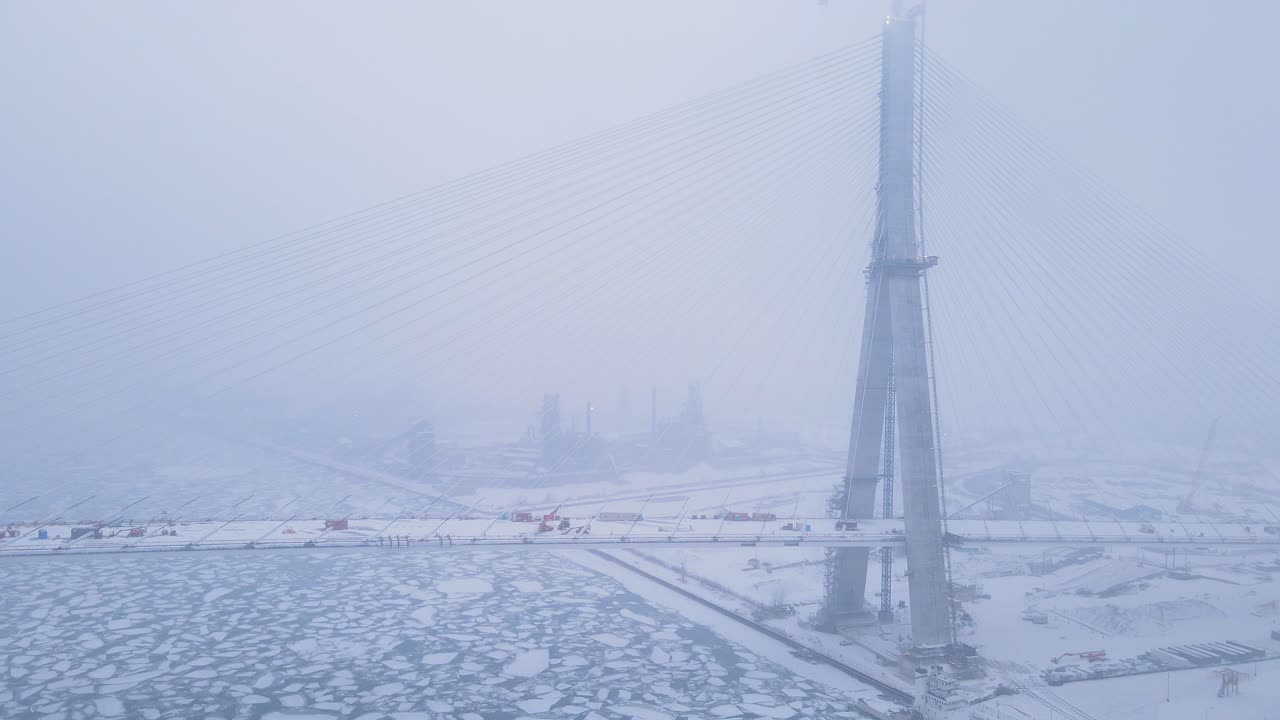 Gordie Howe Bridge structure emerging in snowstorm with limited visibility in drone video