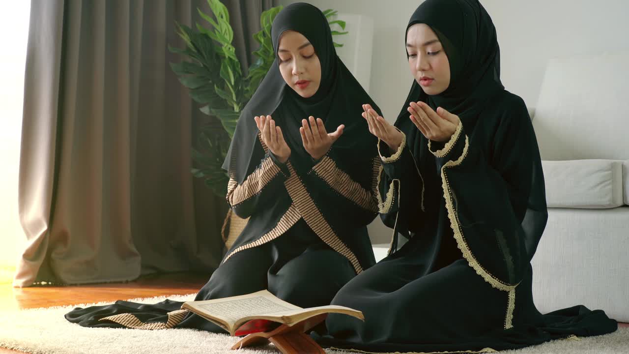 Famiglia musulmana asiatica che prega e si prostra a casa