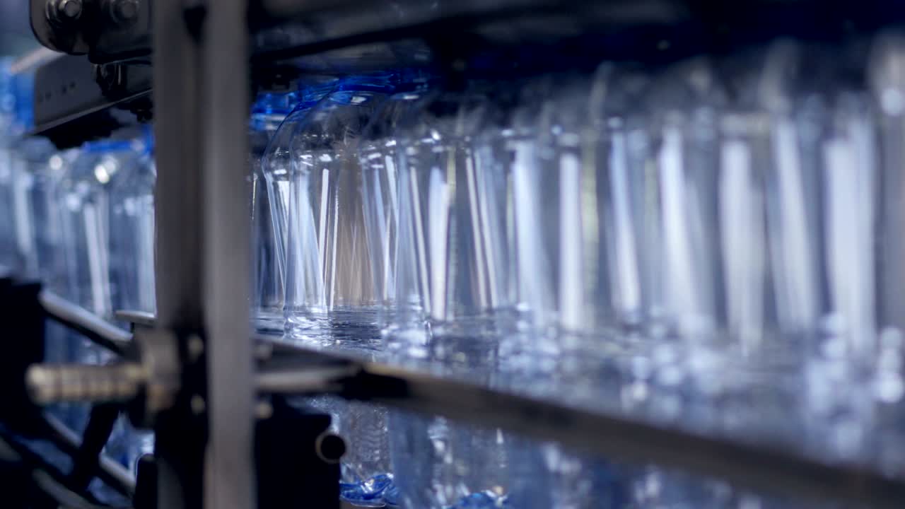 A tight line of empty 32 z bottles on factory line.