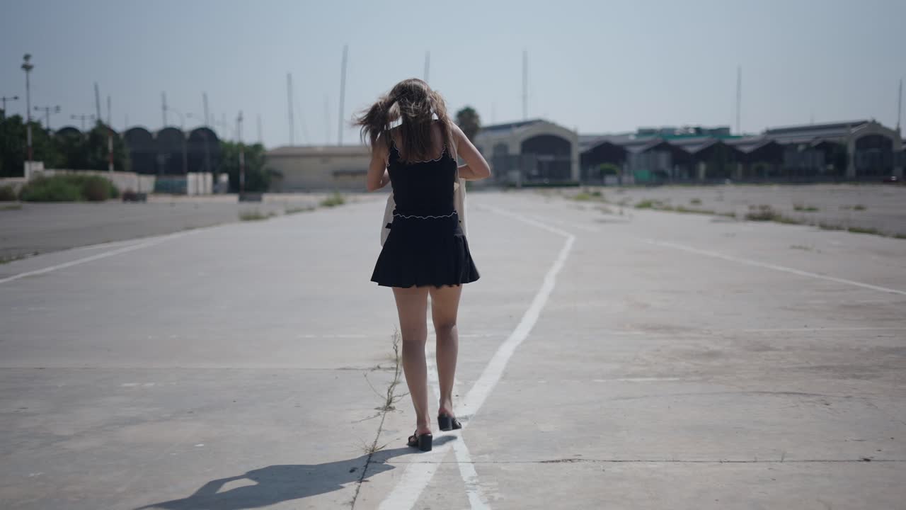 Woman walking on an empty city road