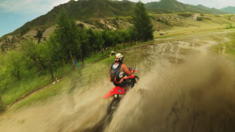 sportsman rides motorcycle crosses muddy puddles fpv. biker in uniform on modern vehicle walkthroughs offroad route area. impressive extreme racing