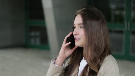 attractive girl outside talking on phone, looking serious