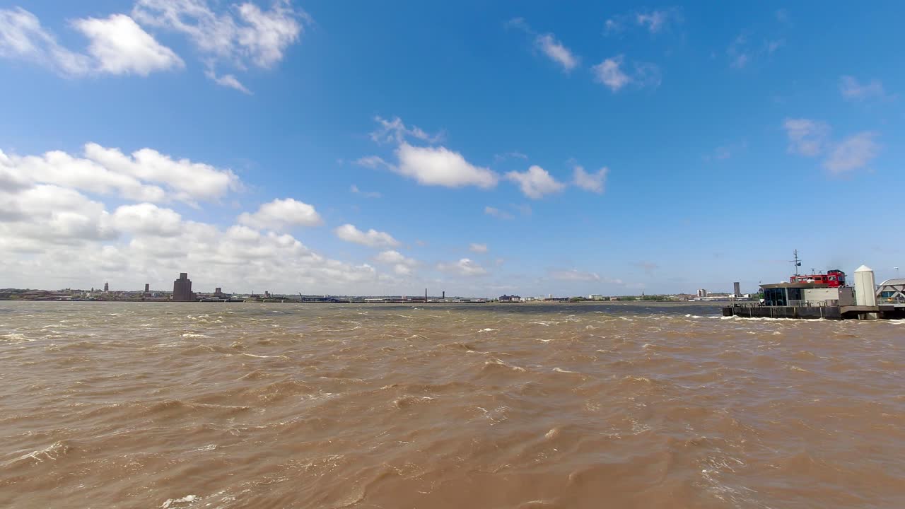 리버풀 워터프론트 부두를 출발하는 스노우드롭 페리 보트로 머시 강에 그림자를 드리우는 저속 구름