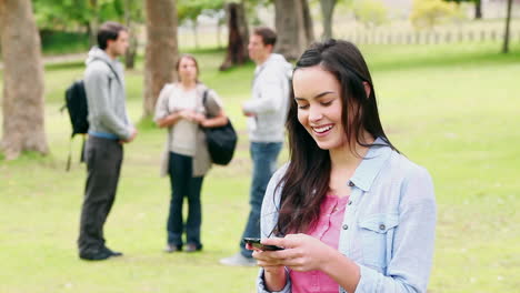 A-woman-laughs-while-reading-a-text-message-before-looking-at-the-camera