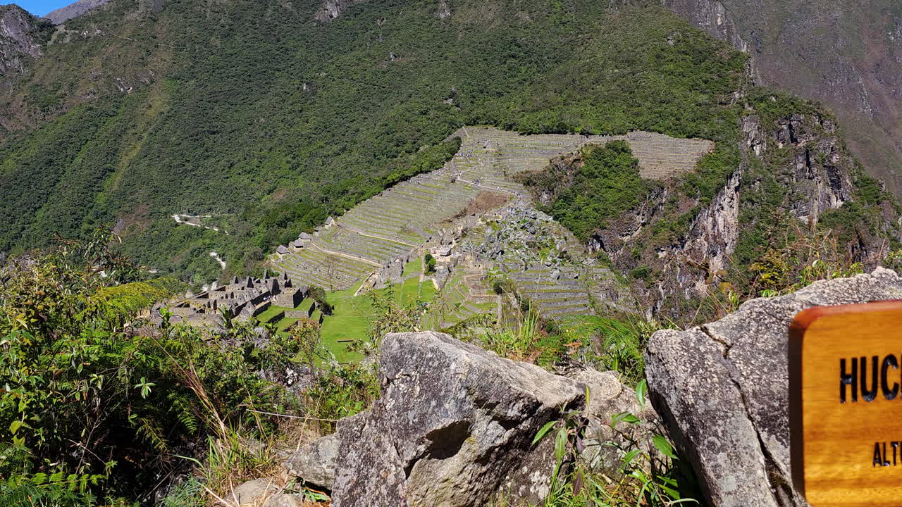 Panoramic video from the summit of Huchuy Picchu mountain, showing a sign with the name and altitude. The incredible views of the Machu Picchu archaeological complex and the surrounding mountains