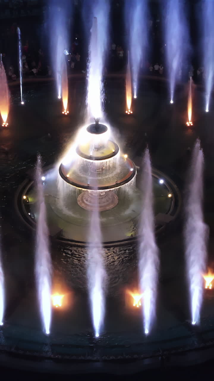Aerial drone view of the illuminated Bucharest fountains in Romania, at night. Vertical