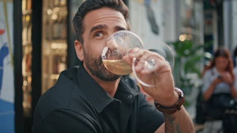 man model enjoying alcohol summer cafe bar close up. guy drinking wine portrait