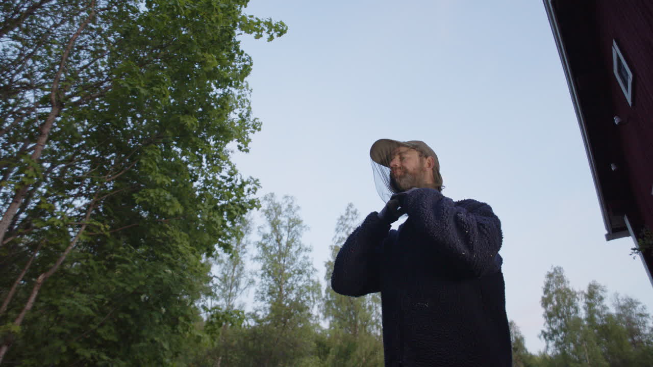 Man puts on mosquito head net to protect body against pesky summer mosquitoes