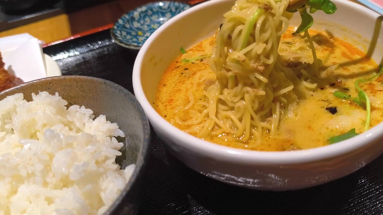 Primo piano di un set di ramen con bacchette che afferrano, insieme a riso e sottaceti, piatto da ristorante asiatico