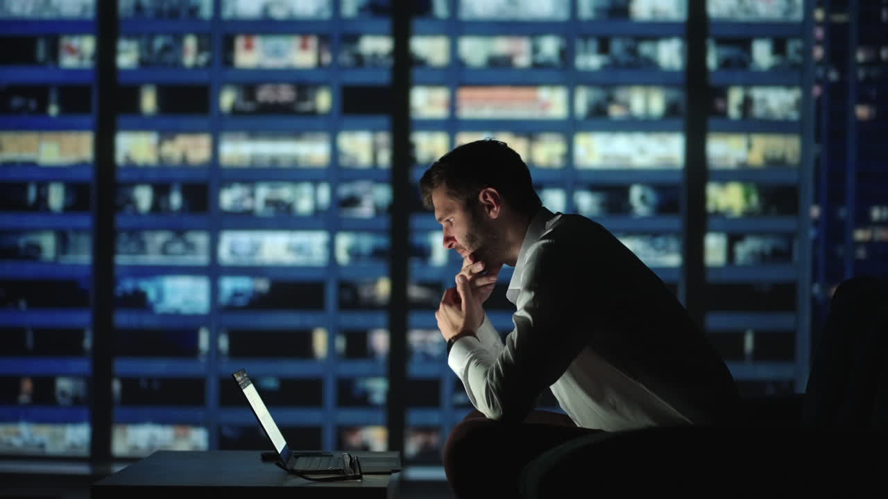 진지한 사람 직원은 책상에 앉아 아이디어를 개발하고 시작하고 문제 해결책을 찾고 열심히 일하며 현대 마천루 사무실에서 밤에 노트북 앱을 사용합니다. 마감일 경력주의 업무중독 개념