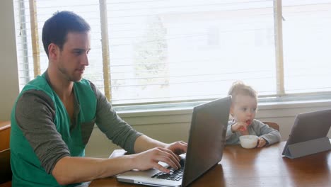 Vater-Benutzt-Laptop,-Während-Kleiner-Junge-Frühstückt-4k