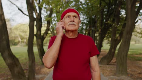 senior runner man in park using smart watch, tracking distance, checking pulse after fitness workout