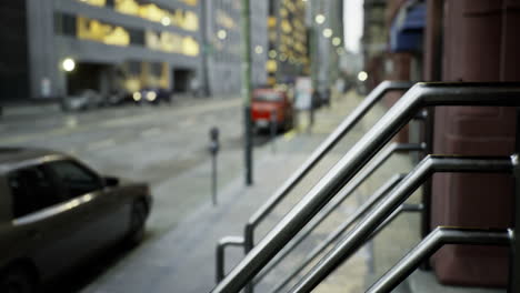 view of a quiet city street with metal handrails during early evening hours