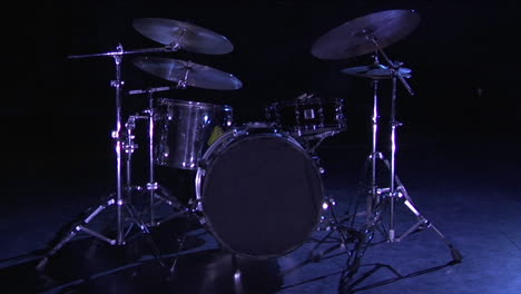 a drum set sits on a dark stage