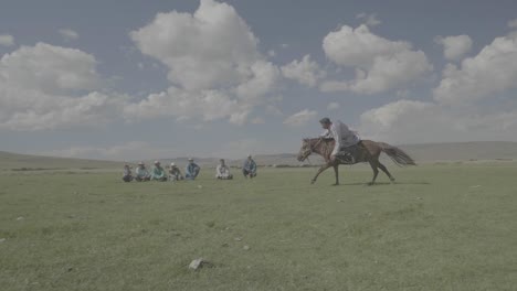 Man-catching-a-wood-stick-on-the-floor-while-riding-a-horse-slow-motion