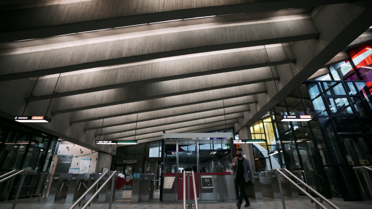 incline hacia abajo para revelar al hombre enmascarado a punto de viajar a través de la estación vacía, pandemia de coronavirus