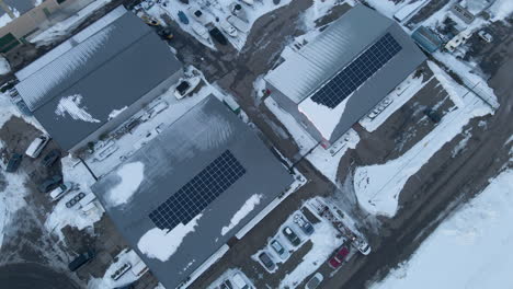 Antenne-Von-Sonnenkollektoren-Auf-Industriehallen-Im-Winter---Drohne-Hebt-Und-Kippt-Nach-Unten