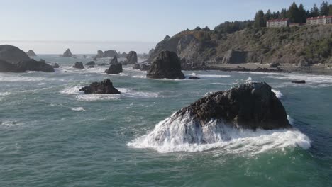 4K-Drohnenaufnahmen-Einer-Welle,-Die-Auf-Eine-Felsklippe-Stürzt,-Mit-Fliegenden-Möwen-In-Brookings,-Oregon