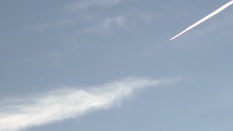 a jet leaving contrails in the sky as it flies across the land